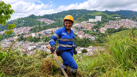 Mujer con uniforme en ladera con paisaje de ciudad atras 